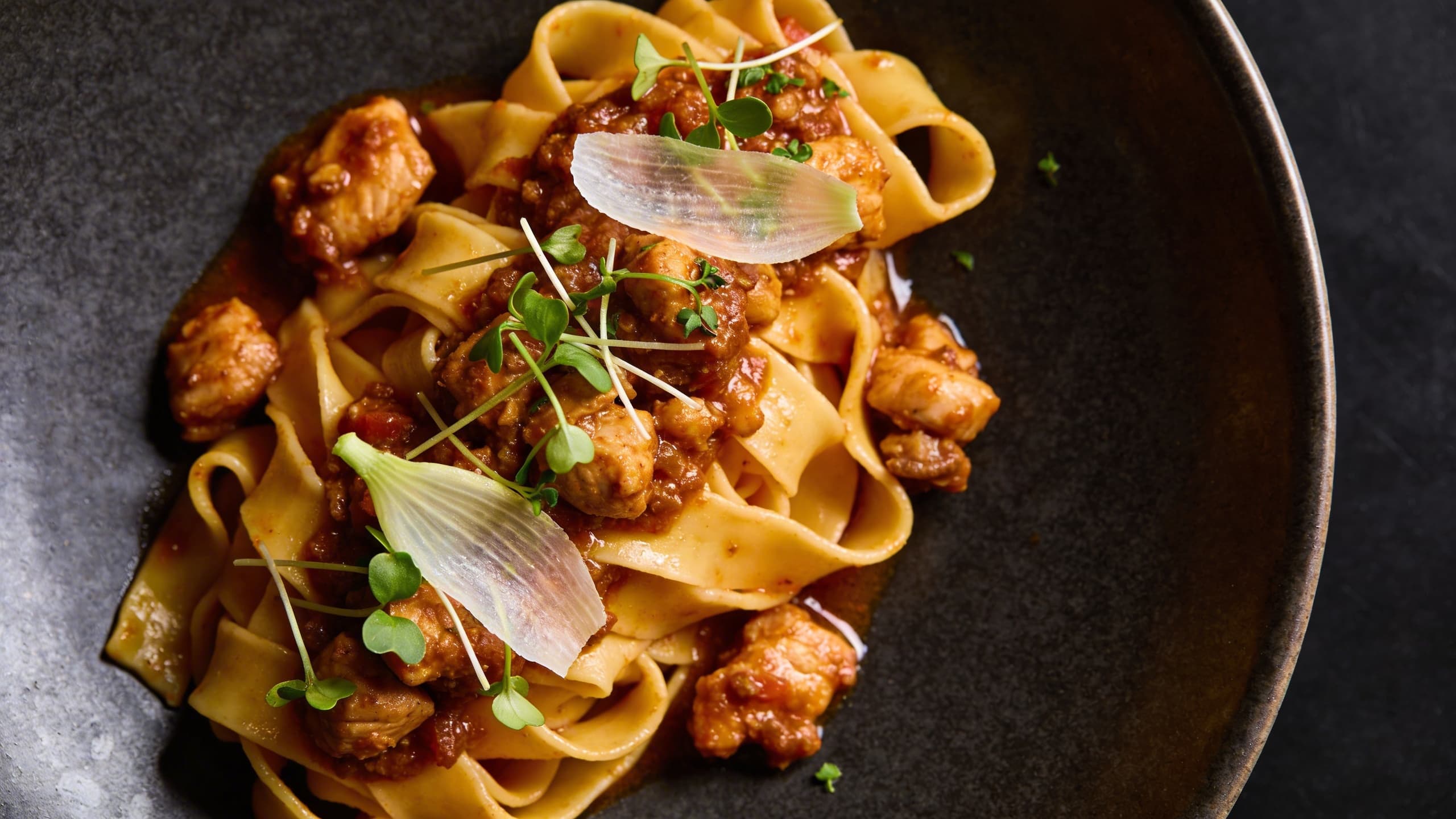 Hand-torn braised rabbit tossed with wide ribbons of pappardelle, garnished with fresh herbs and thin slivers of galangal