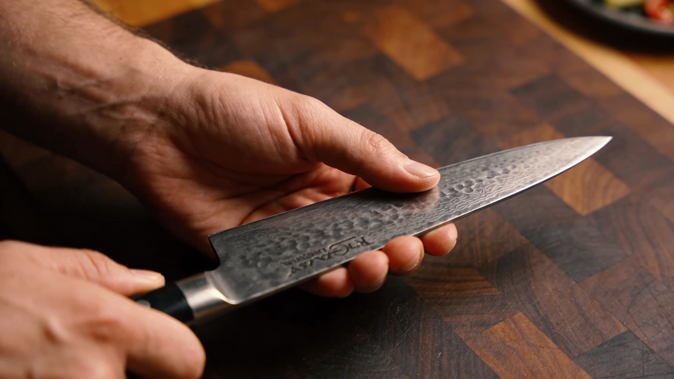 Image 1: A professional chef demonstrating the 'Pinch Grip'—thumb and forefinger gripping the blade's bolster for maximum control and safety.
